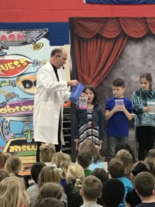 Marty the Magician performing the Wacky Science Show to a group of elementary school children.